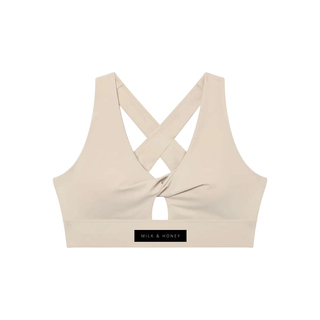 Sleeveless twist-front sports bra with wide crisscross back straps, small front keyhole and 'MILK & HONEY' label on band