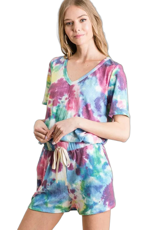 Model wearing tie-dye shorts with drawstring pockets and matching V-neck top in blue, pink, green and yellow.