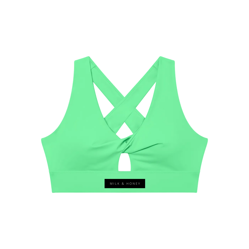 Green twist-front sports bra with crossed back straps, center keyhole and wide underband with MILK & HONEY label.
