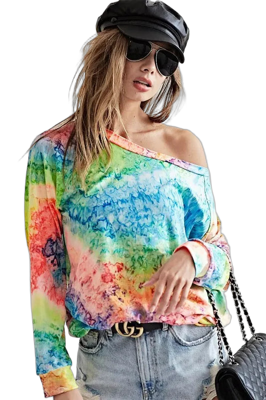 Multicolor tie-dye long-sleeve soft-knit top with off-shoulder neckline, tucked into light-wash jeans, black cap