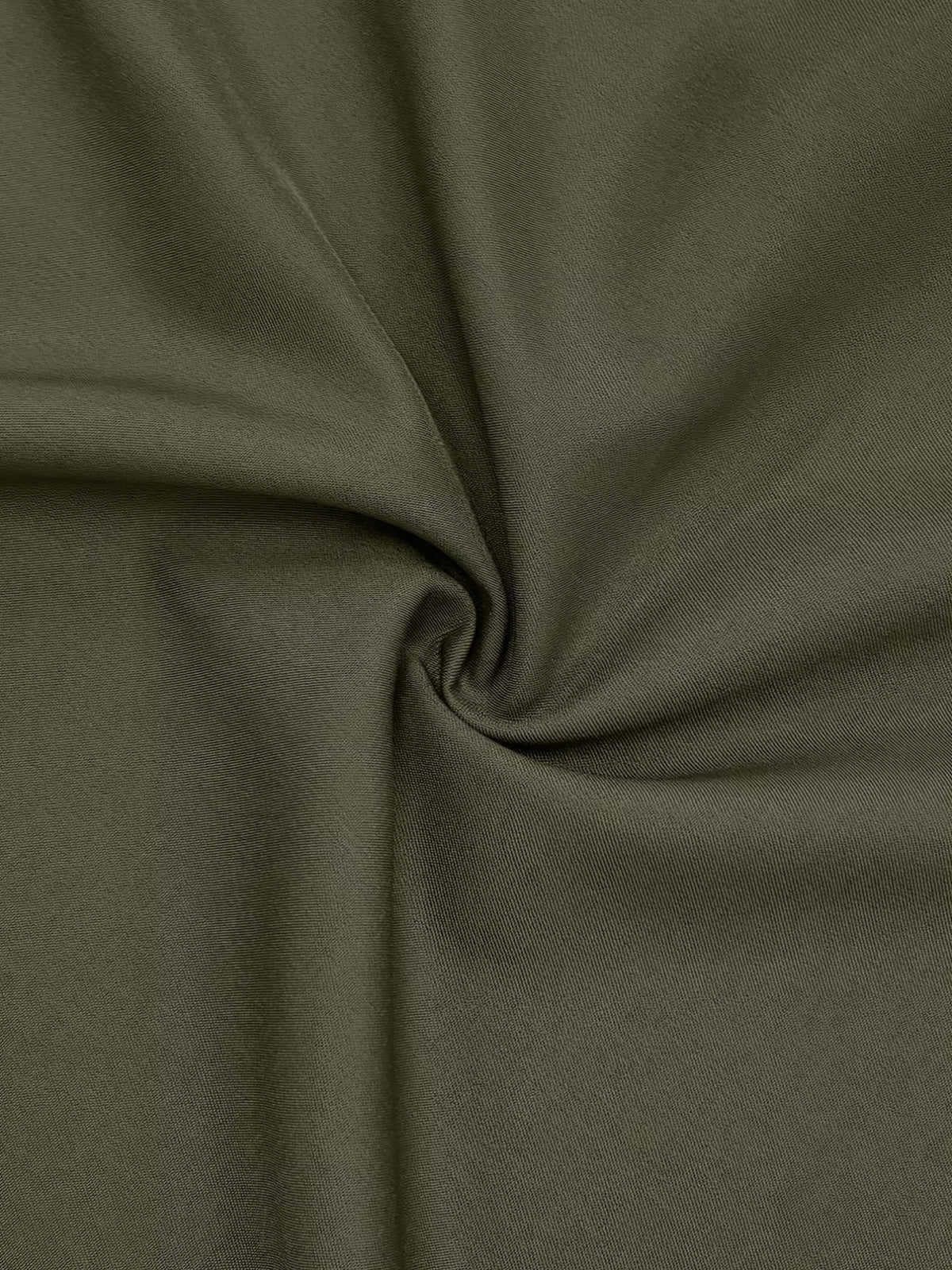 Olive-green fabric with fine textured weave gathered into a central swirl