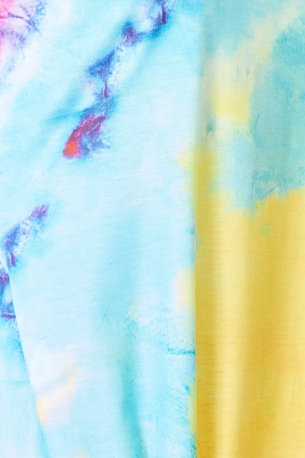 Light blue and yellow tie-dye fabric with purple and pink splotches and soft drape