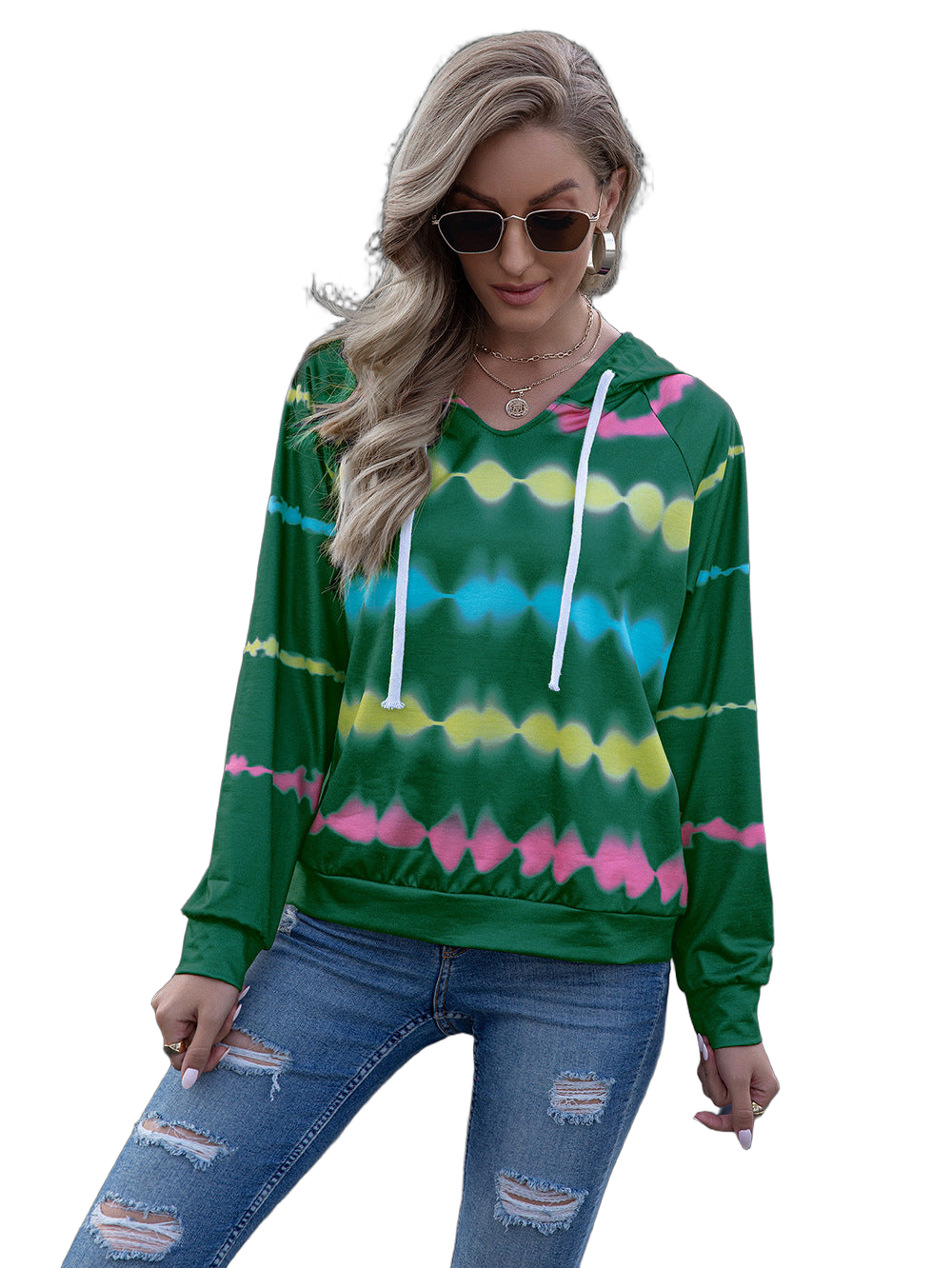 Model wearing green tie-dye hooded raglan sweatshirt with white drawstrings, layered necklaces and ripped denim jeans