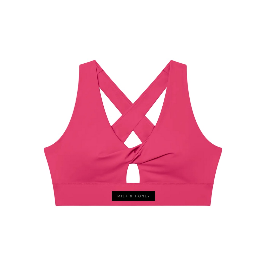 Pink twist-front sports bra with crossed back straps, small front keyhole and wide branded band