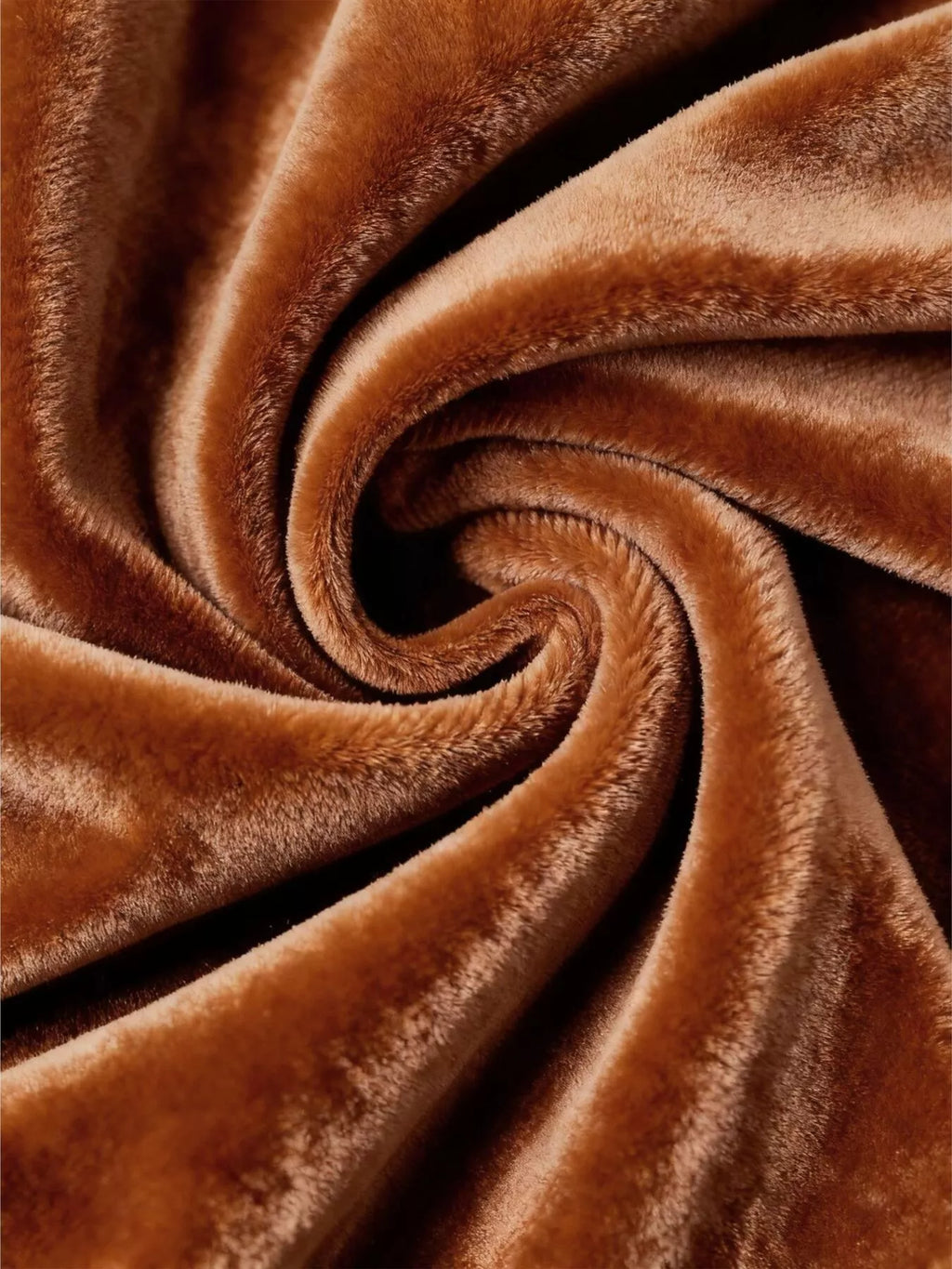Caramel velvet fabric with plush pile folded into spiral swirls