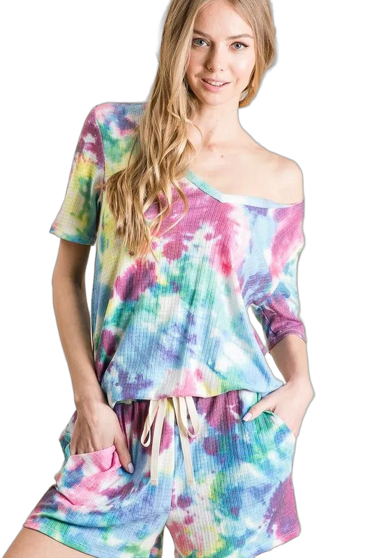 Woman wearing matching tie-dye French terry shorts with drawstring and side pockets, paired with off-shoulder top