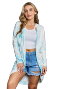 Model wearing light blue tie-dye longline open-front cardigan over white crop tank and distressed denim shorts
