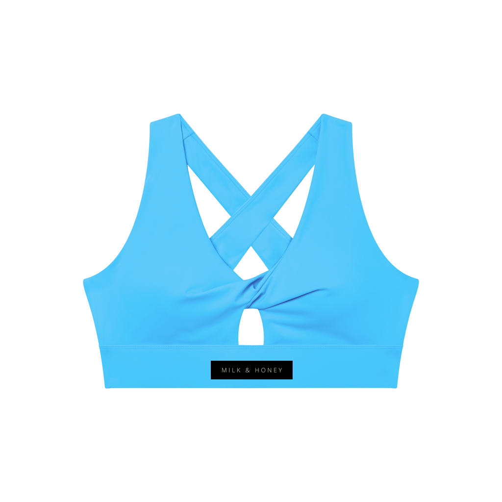 Blue sports bra with crossed back straps, center keyhole and wide elastic band labeled MILK & HONEY