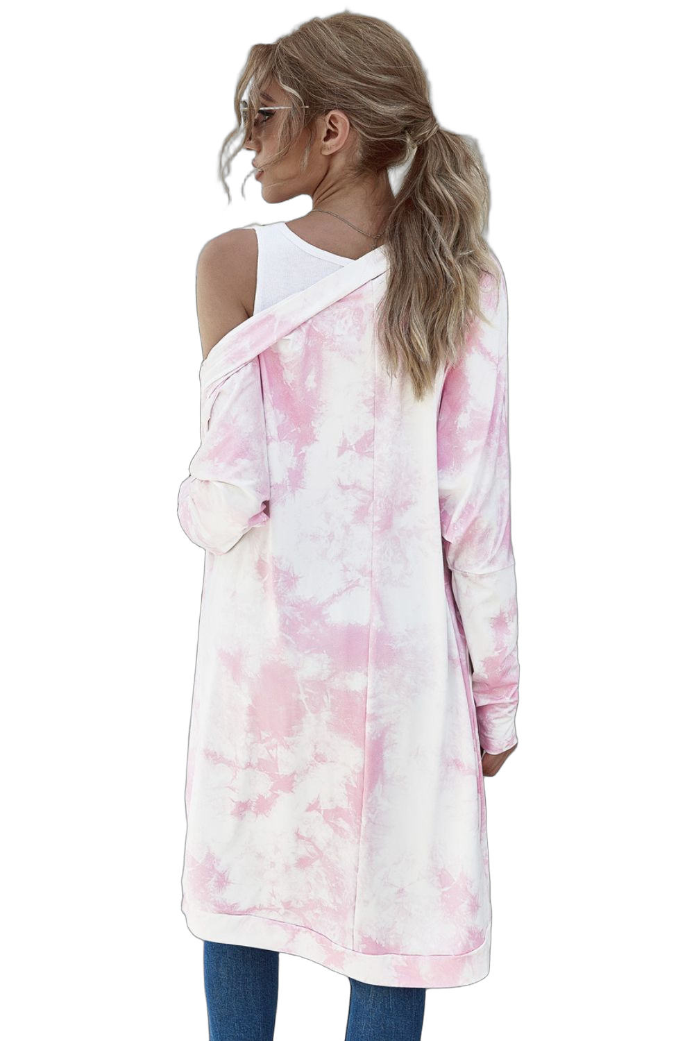 Back view of model wearing long pink-and-white tie-dye open-front cardigan, showing white tank, hair in ponytail, blue jeans