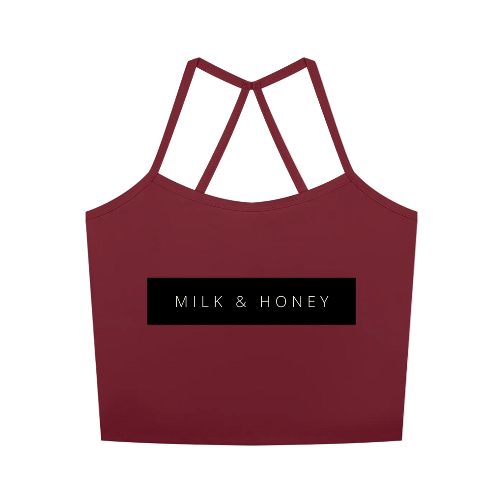 Cropped red tank with thin crossed racerback straps and centered black rectangle reading 'MILK & HONEY'.