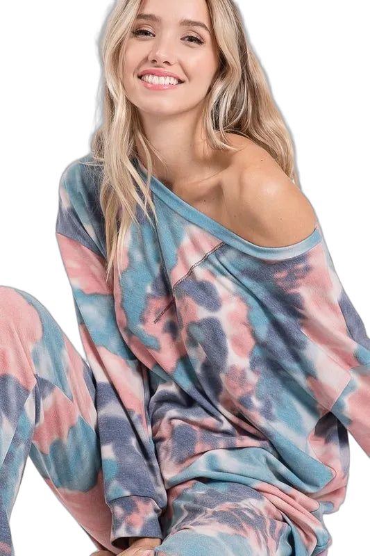 Smiling blonde model in off-shoulder long-sleeve tie-dye loungewear set with matching pants in pastel blue, pink, and gray