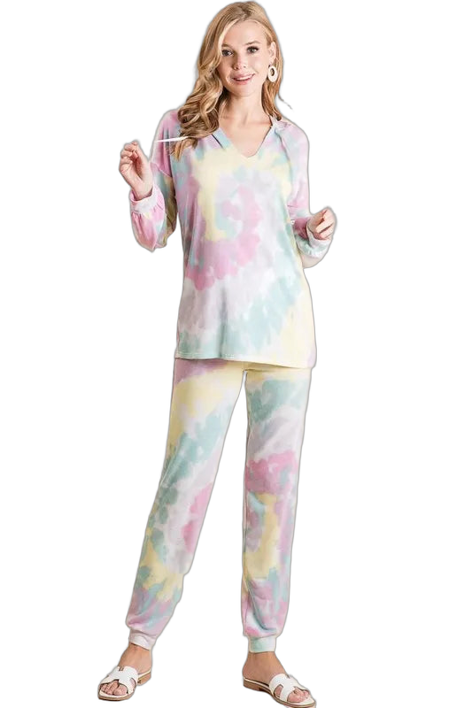 Woman in pastel pink, yellow, mint tie-dye V-neck top and matching jogger pants with drawstring and white sandals