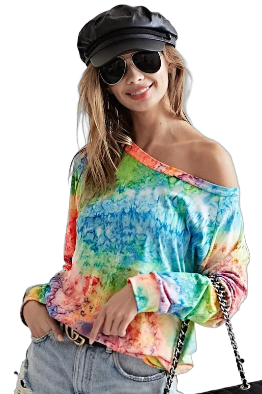 Off-shoulder multicolor tie-dye long-sleeve tee tucked into light-wash jeans, wearing black cap, aviator sunglasses…