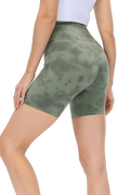 Model wearing high-waist matcha green tie-dye biker shorts, back and side view showing wide waistband
