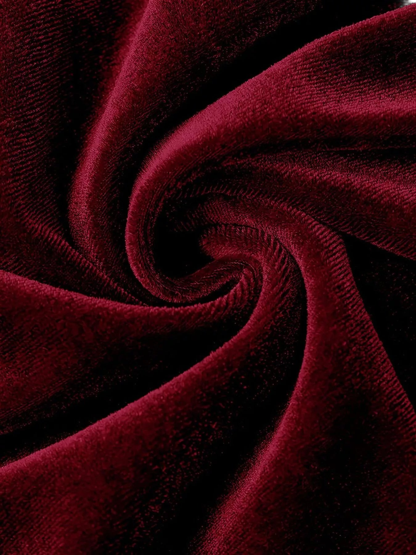 Swirled plush velvet fabric in deep burgundy with visible pile texture