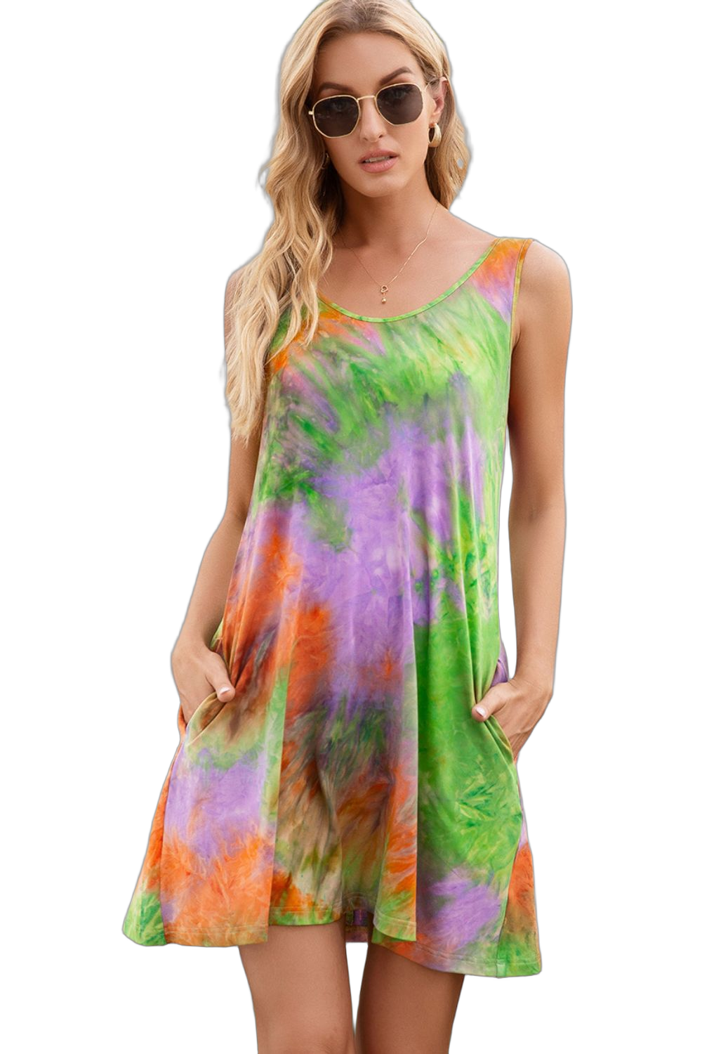 Sleeveless round-neck tie-dye mini dress with green, purple and orange swirls, model wearing sunglasses, hands in pockets