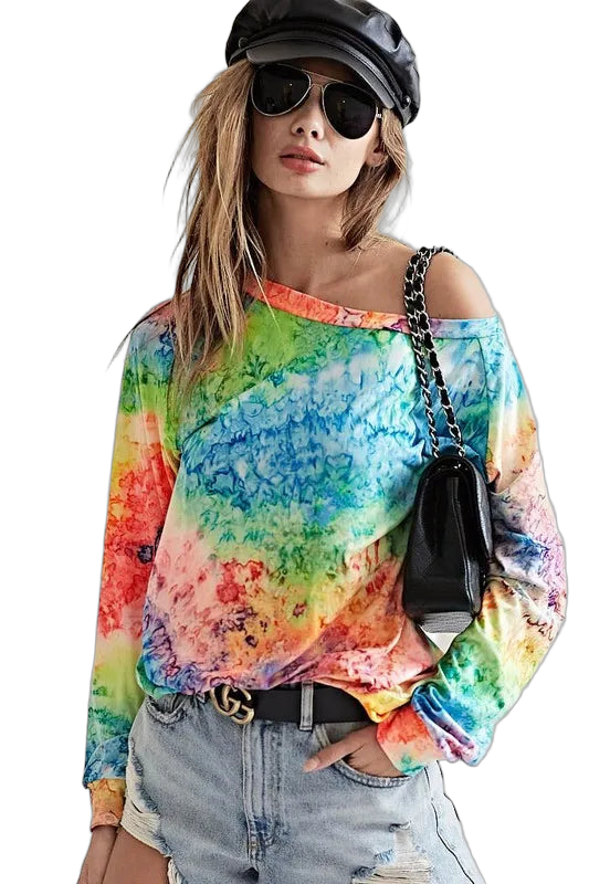 Model wearing rainbow tie-dye long-sleeve off-shoulder top, distressed denim shorts, black chain-strap bag and cap