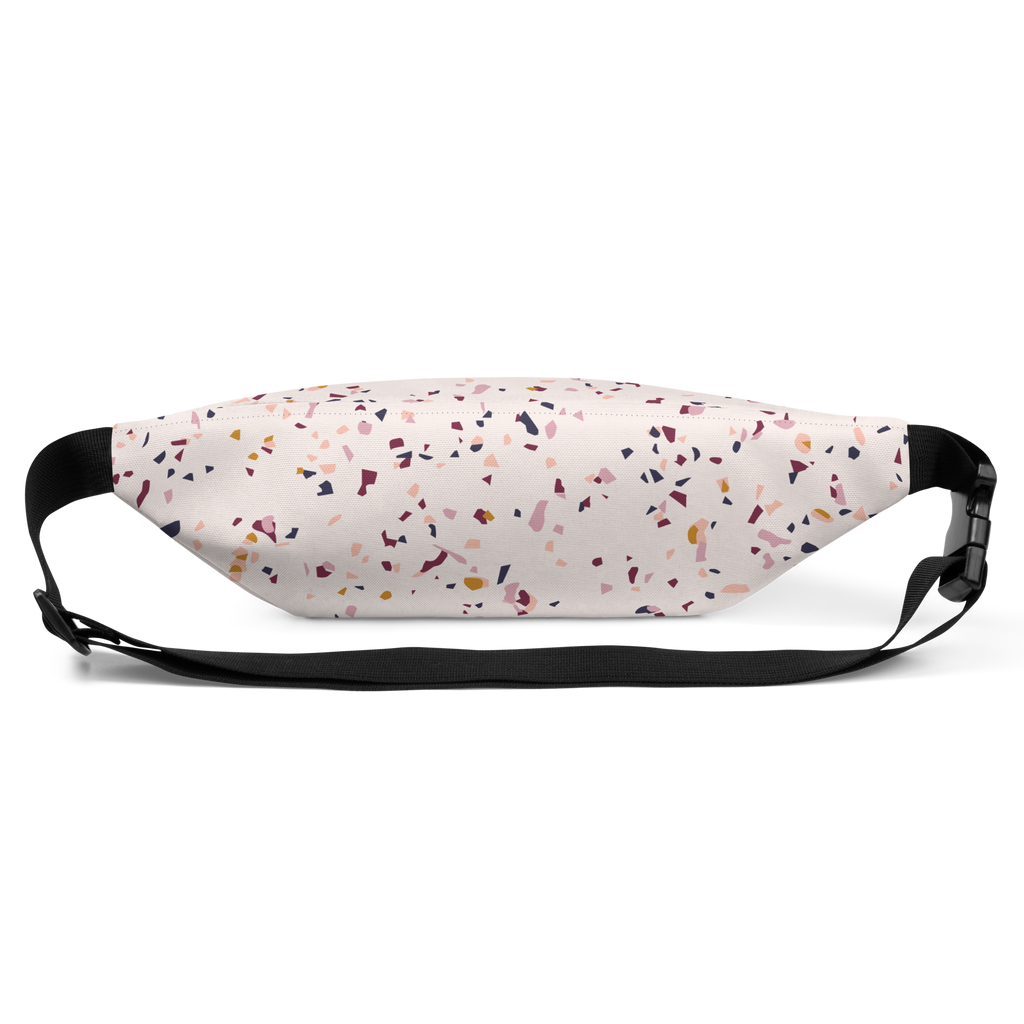 Fanny pack with pale background and scattered multicolor confetti print, black adjustable straps and buckle