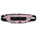 Top view of a pink fabric fanny pack with blue doodle pattern, black "MILK & HONEY" label, zipper and black adjustable strap
