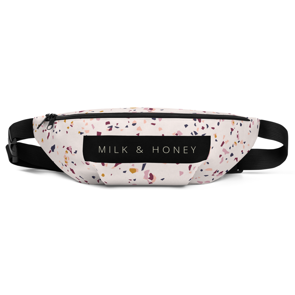 Top view of terrazzo-pattern fanny pack with black zipper, dual sliders, MILK & HONEY label and adjustable black straps