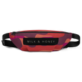 Zippered top of fanny pack with black 'MILK & HONEY' label, abstract red-orange-purple print, and adjustable black strap