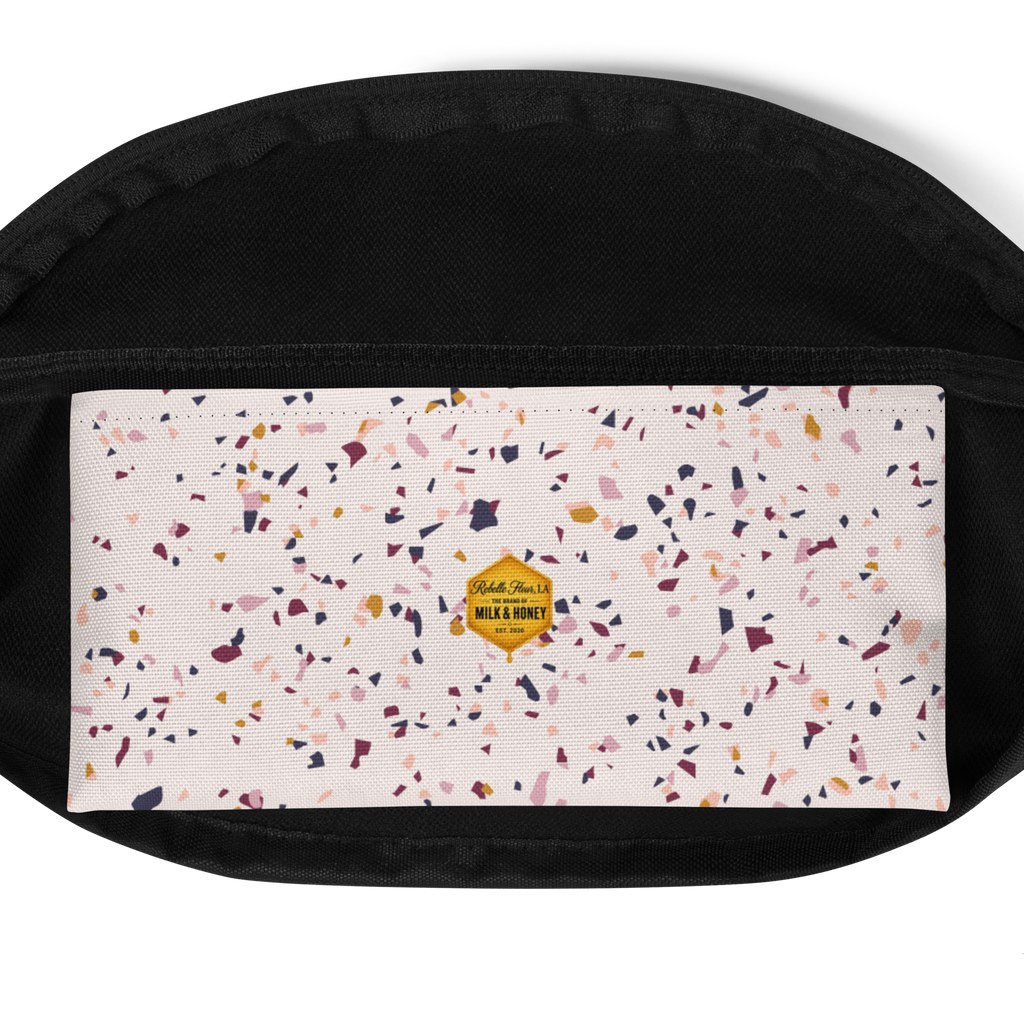 White front panel with multicolor confetti terrazzo print and small yellow hexagon 'Milk & Honey' logo, black fabric trim
