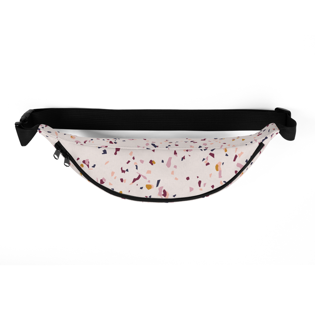 Black adjustable waist strap and zipper over light fabric with scattered confetti-like print and visible zipper pull