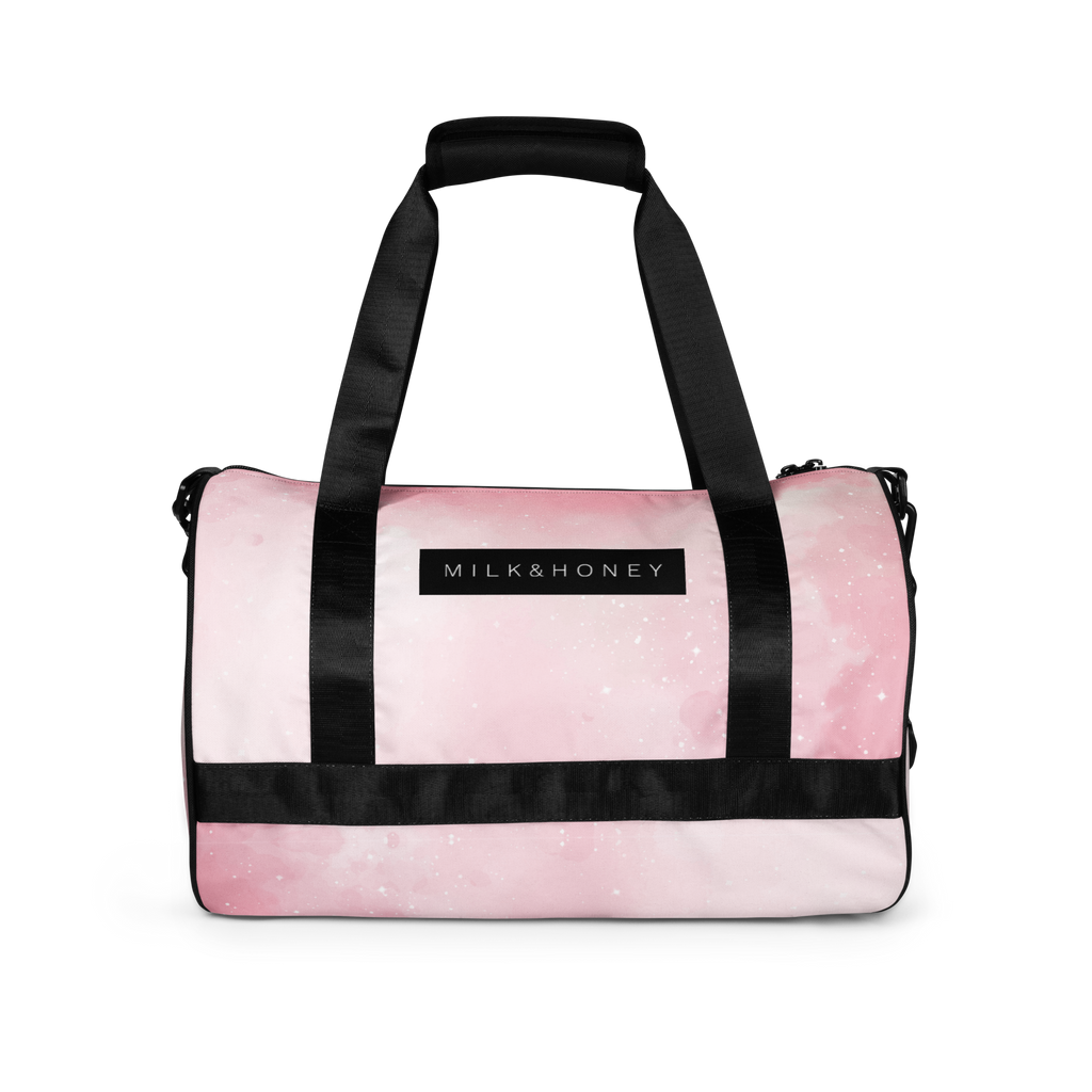 Pink duffel top with black padded handle, wide black straps and a rectangular "MILK & HONEY" label