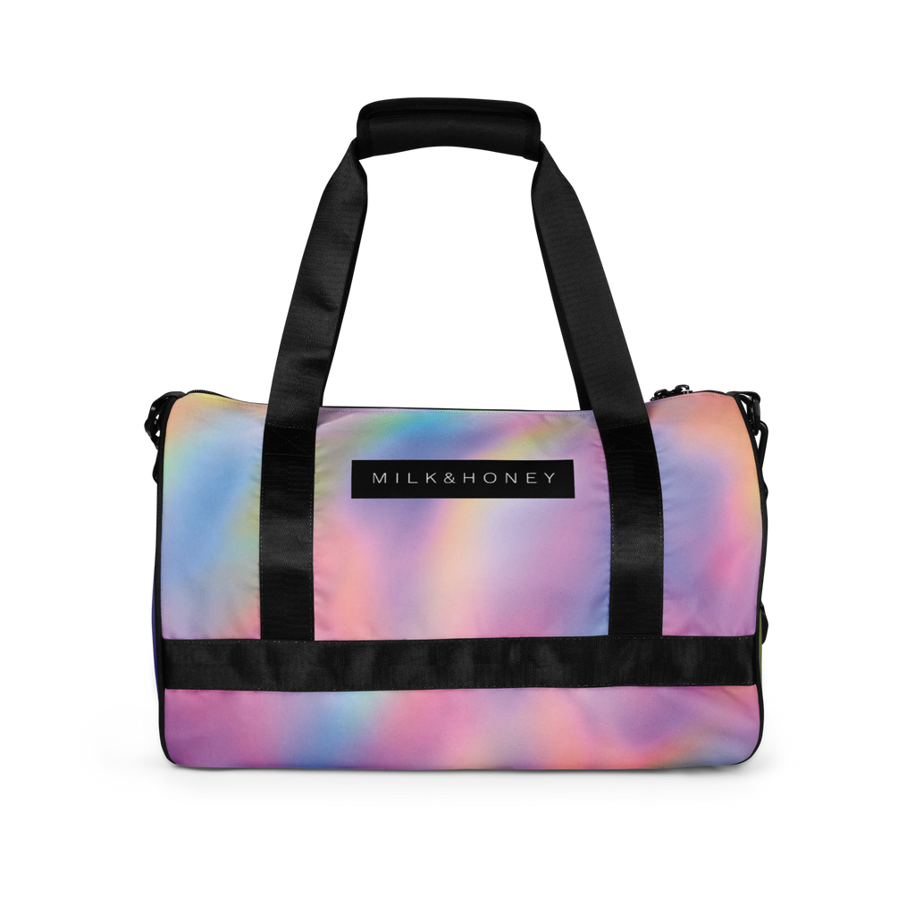 Black padded handles and straps over pastel rainbow duffel front with MILK&HONEY label