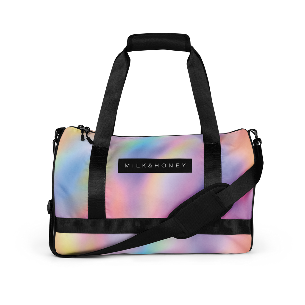 Pastel gradient duffel with black padded carry handles, adjustable shoulder strap, zipper pulls, and MILK&HONEY label