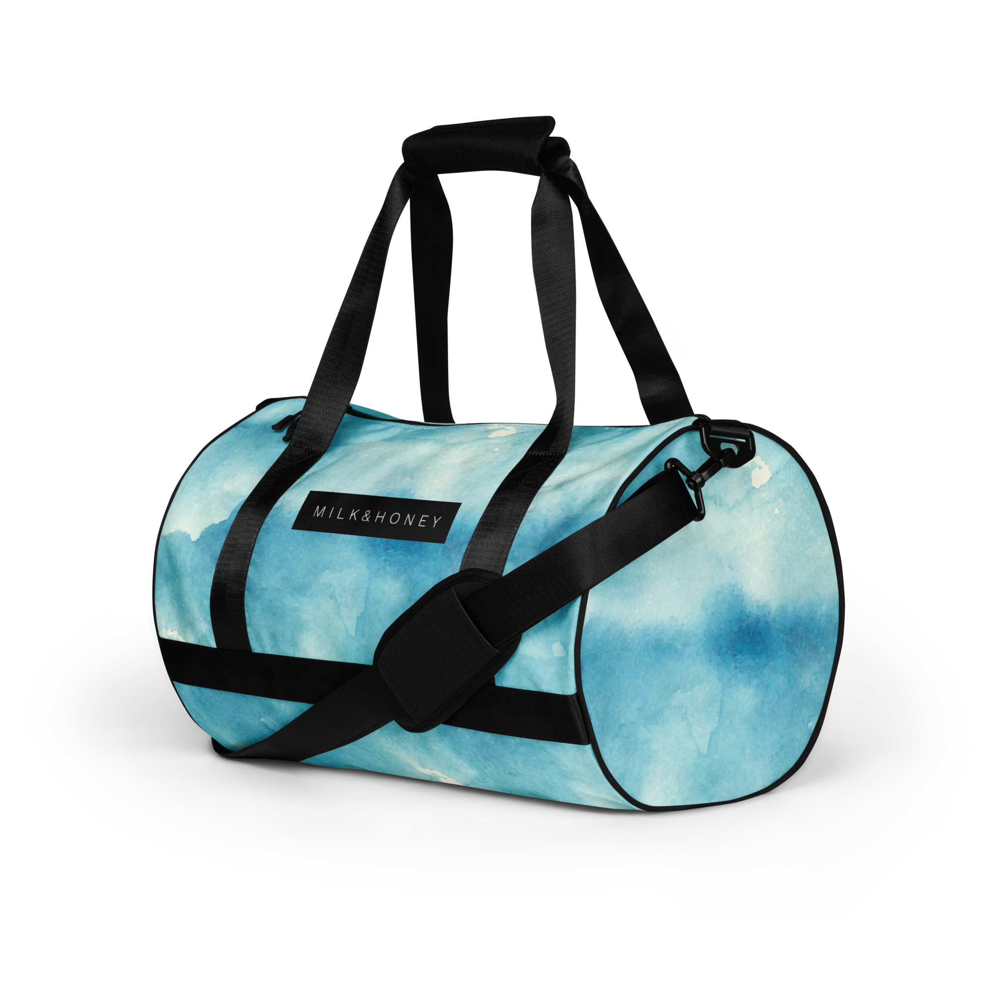 Turquoise watercolor duffel with black webbing straps, padded shoulder pad, swivel clip and MILK&HONEY label