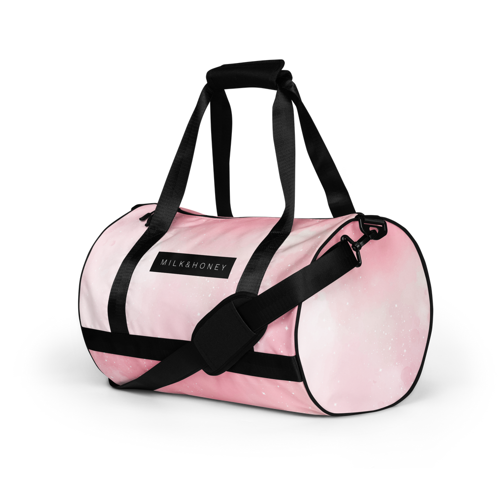 Pink duffel top with black padded handles, adjustable shoulder strap and MILK&HONEY label