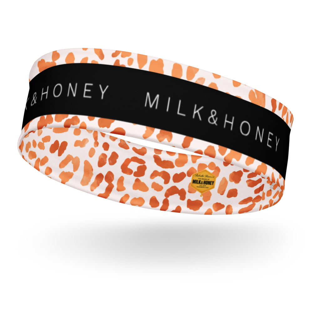 Headband with orange leopard spots on pale background, black center band reading MILK&HONEY, small yellow logo tag