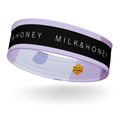 Lavender headband with black band reading 'MILK & HONEY', pale dot pattern and small hexagon Rebelle Fleur logo