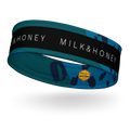 teal patterned headband with black band reading 'MILK & HONEY' and small yellow Rebelle Fleur hexagon logo
