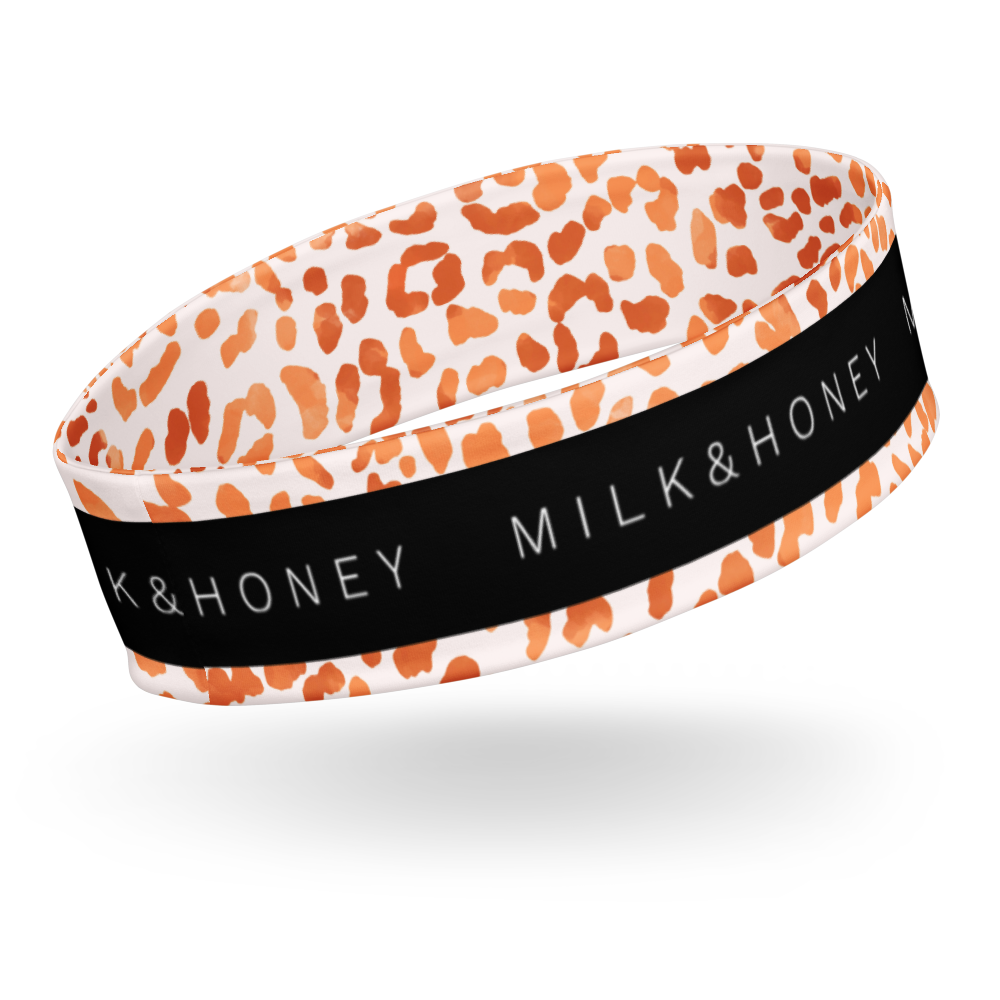 Orange and white spotted headband with a black center band reading MILK & HONEY