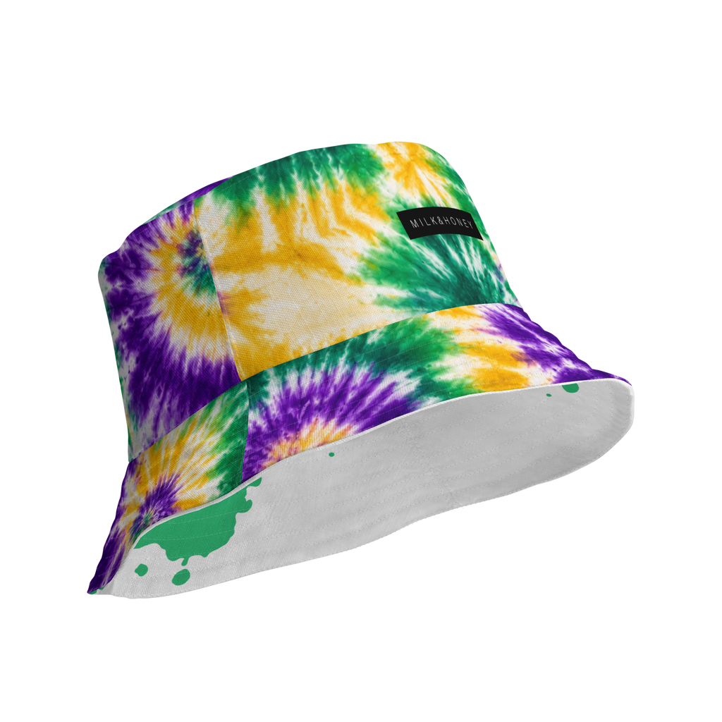 Tie-dye bucket hat with green, yellow and purple swirls, MILK&HONEY label and white brim with green paint splatter