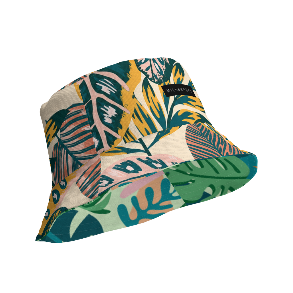 Tropical leaf-pattern reversible bucket hat with teal, green, yellow and pink accents and 'MILK&HONEY' label