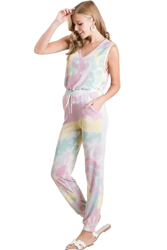 Woman wearing pastel tie-dye jogger pants with drawstring and side pockets, paired with sleeveless top and sandals.
