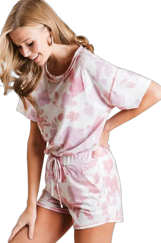 Model wearing matching pink-and-white tie-dye shorts with drawstring and side pockets, paired with a short-sleeve top