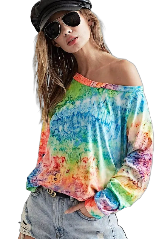 Woman wearing off-shoulder rainbow tie-dye long-sleeve tee tucked into denim shorts, black cap and sunglasses