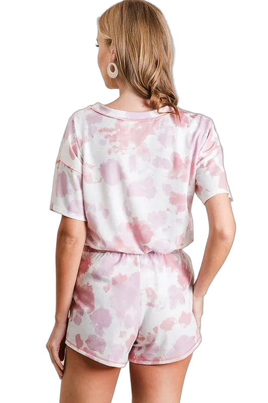 Back view of woman wearing pink and white tie-dye terry shorts and matching short-sleeve top, elastic waistband