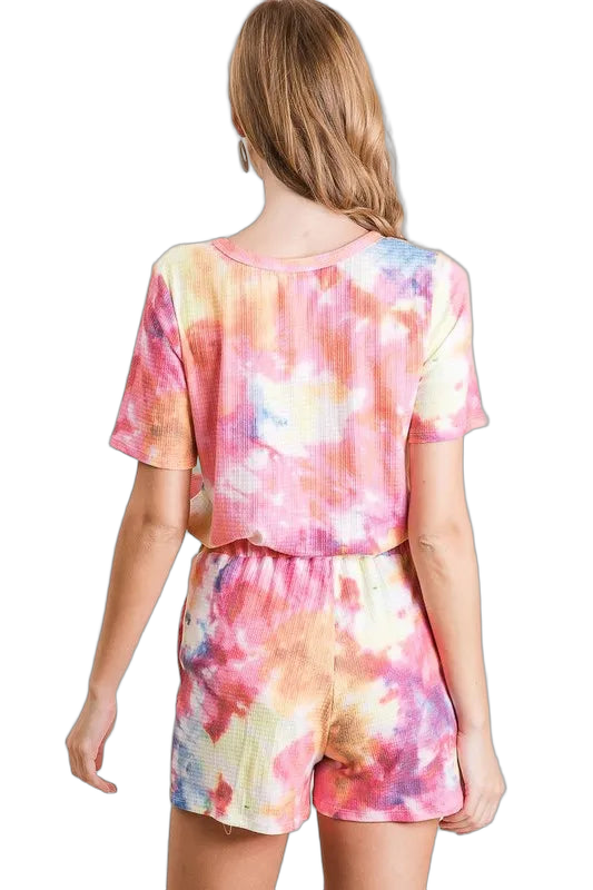 Back view of model wearing pastel tie-dye ribbed shorts with elastic drawstring waist and matching short-sleeve top