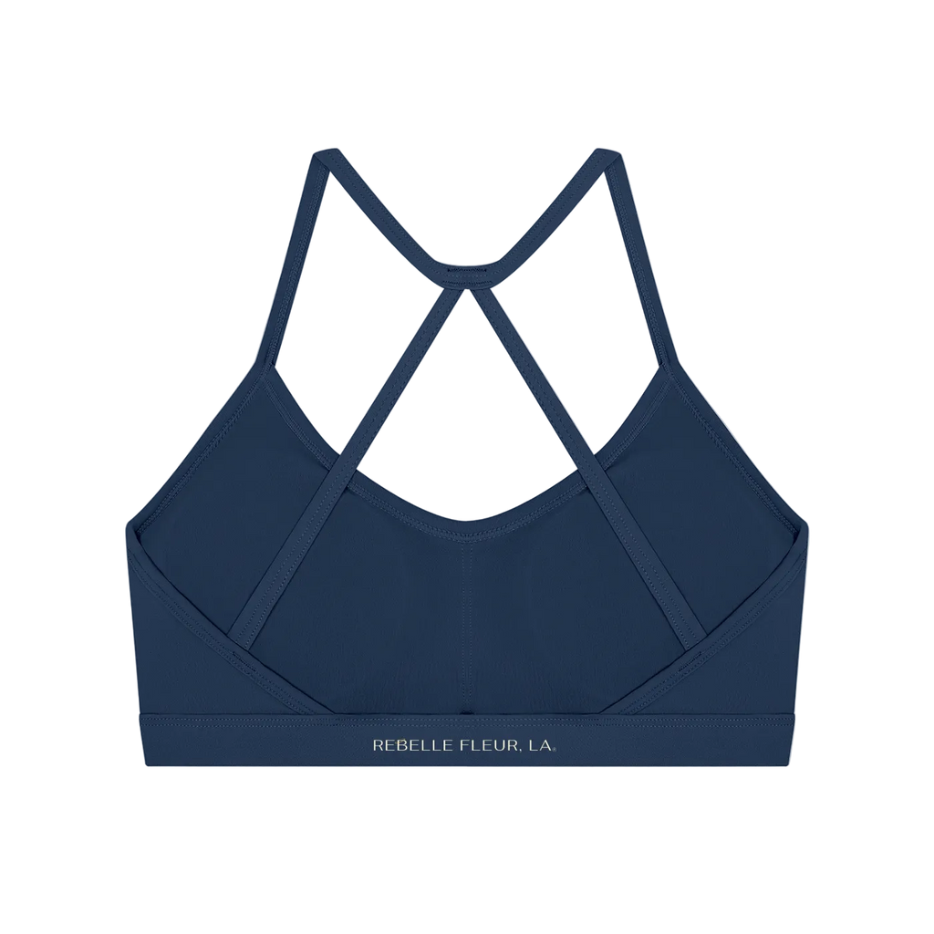 Back view of a navy strappy sports bra with X-back narrow straps and elastic band labeled 'REBELLE FLEUR, LA'
