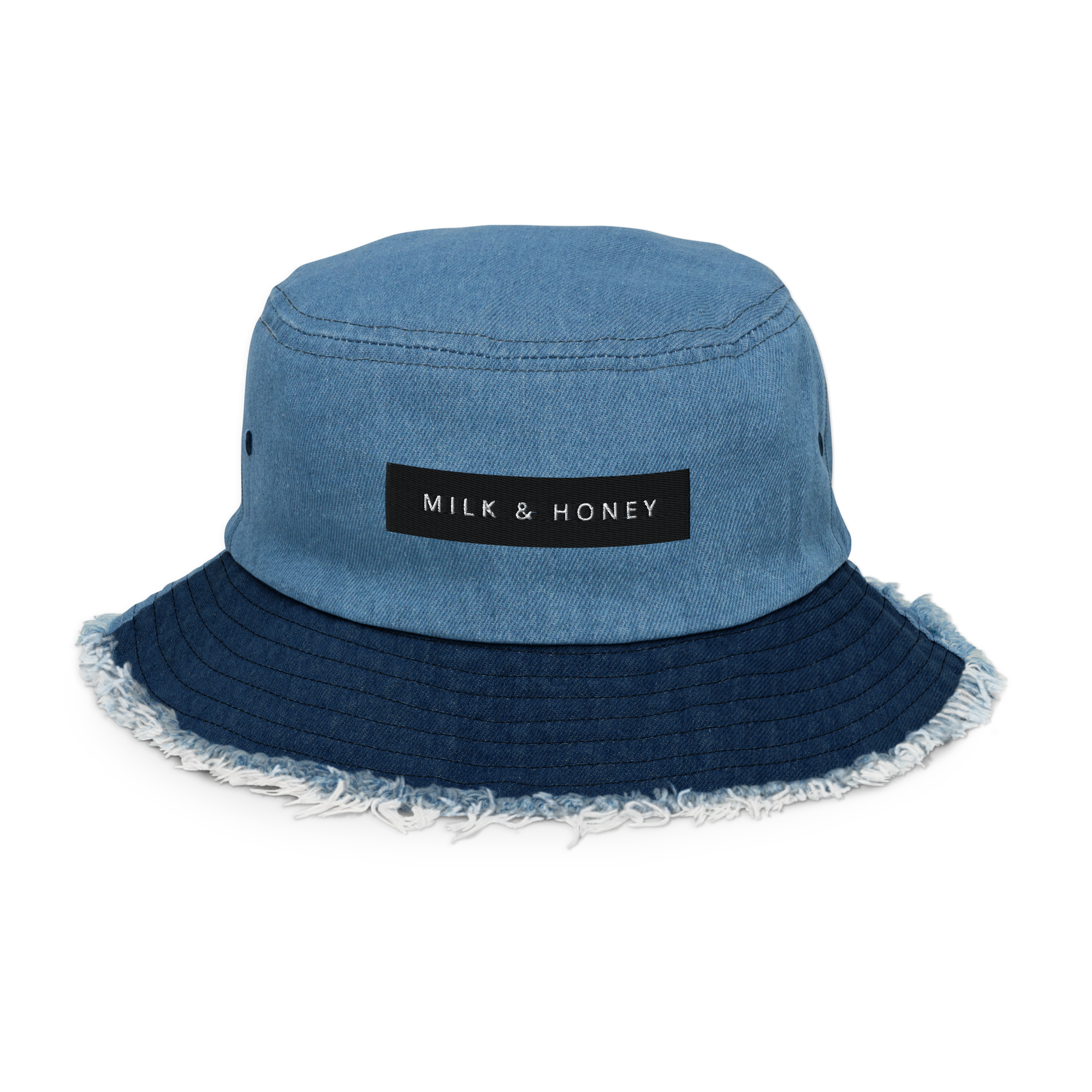Light denim bucket hat top with stitched seams, rectangular 'MILK & HONEY' label, darker frayed brim and side eyelet
