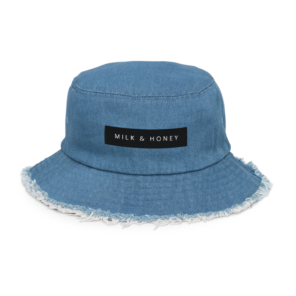 Light denim bucket hat with frayed brim and black rectangular 'MILK & HONEY' label