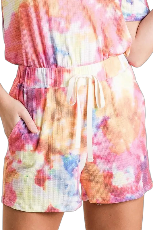 Pink multi tie-dye French terry shorts with elastic drawstring waist and side pockets, worn with matching top