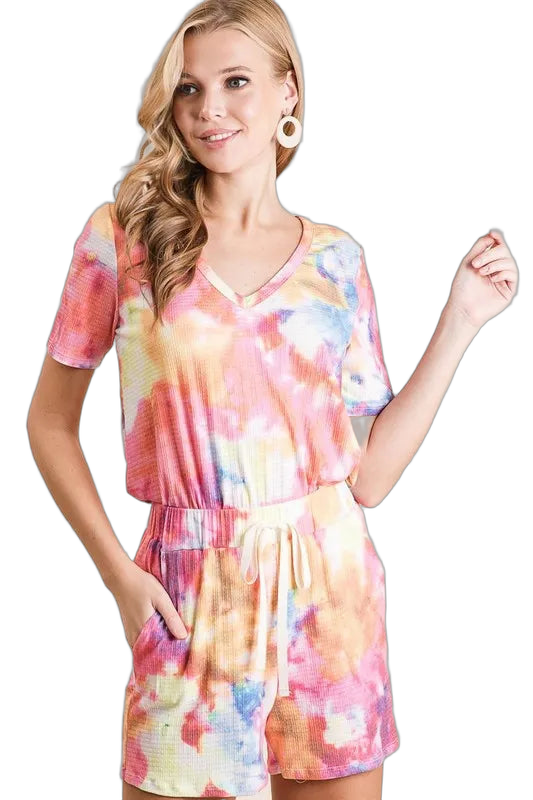 Woman wearing multicolor tie-dye V-neck top and drawstring-waist shorts with side pockets