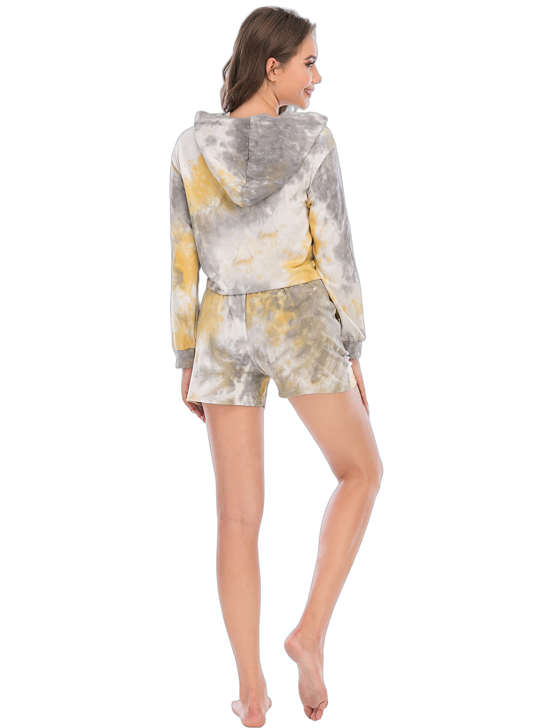 Back view of a model wearing a gray and yellow tie-dye hooded cropped top with matching shorts, standing on tiptoes