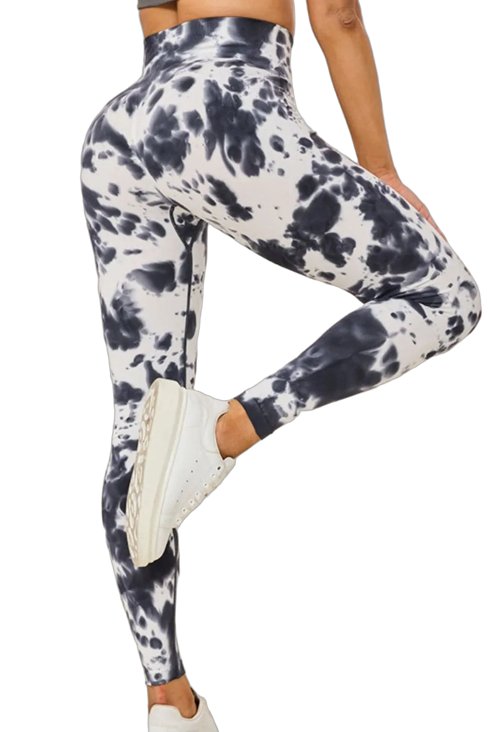 Model wearing high-waist black-and-white tie-dye leggings with cropped midriff and white sneakers